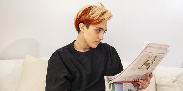 Eine Transperson liest Zeitung Eine Transperson liest Zeitung