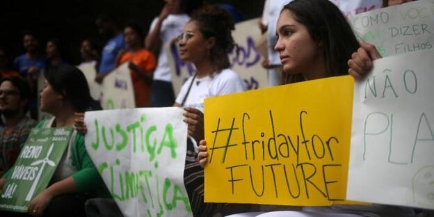 Junge Frauen halten Schilder, auf denen Parolen und "FridaysforFuture" steht Junge Frauen halten Schilder, auf denen Parolen und "FridaysforFuture" steht
