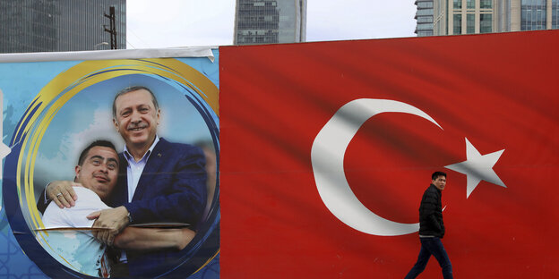 Mann vor türkischer Flagge und Wahlplakat Mann vor türkischer Flagge und Wahlplakat