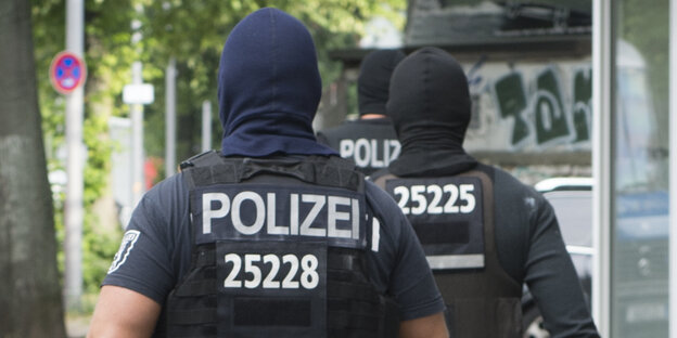 Beamte einer Einsatzhundertschaft der Polizei von hinten Beamte einer Einsatzhundertschaft der Polizei von hinten