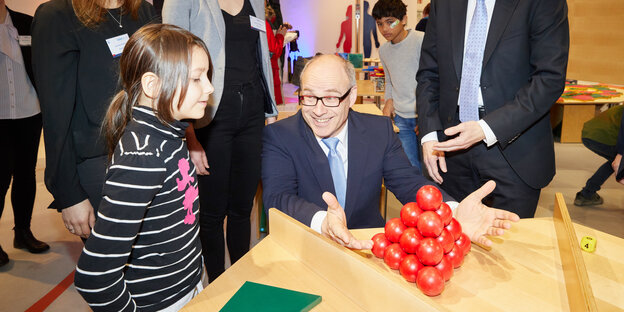 Eine Schülerin und Schulsenator Ties Rabe verständigen sich über ein Zahlen- und Würfelspiel. Eine Schülerin und Schulsenator Ties Rabe verständigen sich über ein Zahlen- und Würfelspiel.