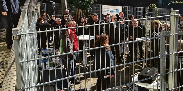 Menschen stehen in einem eingezäunten Bereich in der Nähe des Bremer Hauptbahnhofs. Menschen stehen in einem eingezäunten Bereich in der Nähe des Bremer Hauptbahnhofs.