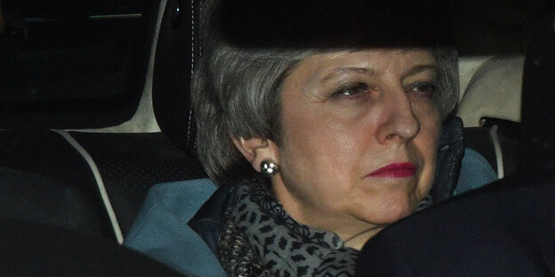 Eine Frau sitzt in einem Auto. Sie guckt ernst. Es ist Theresa May Eine Frau sitzt in einem Auto. Sie guckt ernst. Es ist Theresa May