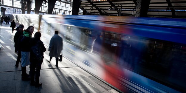 Menschen auf dem Bahnsteig, gerade fährt ein Zug ein Menschen auf dem Bahnsteig, gerade fährt ein Zug ein