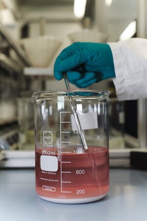 Eine rote Flüssigkeit in einem Glasbehälter im Labor Eine rote Flüssigkeit in einem Glasbehälter im Labor