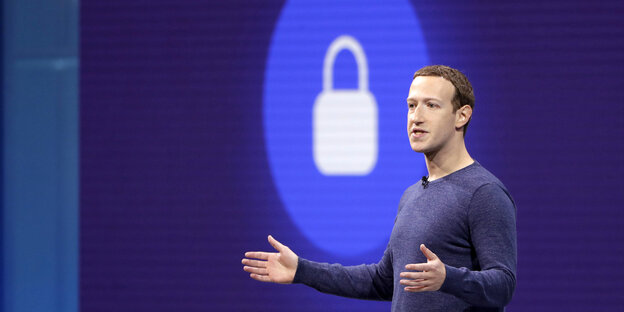 Ein Mann, mark Zuckerberg, vor einem blau-weißen Symbol Ein Mann, mark Zuckerberg, vor einem blau-weißen Symbol