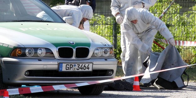 Beamte der Spurensicherung der Polizei arbeiten am 25.04.2007 auf der Theresienwiese in Heilbronn (Baden-Württemberg) an einem Tatort, an dem zuvor eine Polizeibeamtin getötet und ein weiterer Beamter schwer verletzt wurde. Beamte der Spurensicherung der Polizei arbeiten am 25.04.2007 auf der Theresienwiese in Heilbronn (Baden-Württemberg) an einem Tatort, an dem zuvor eine Polizeibeamtin getötet und ein weiterer Beamter schwer verletzt wurde.