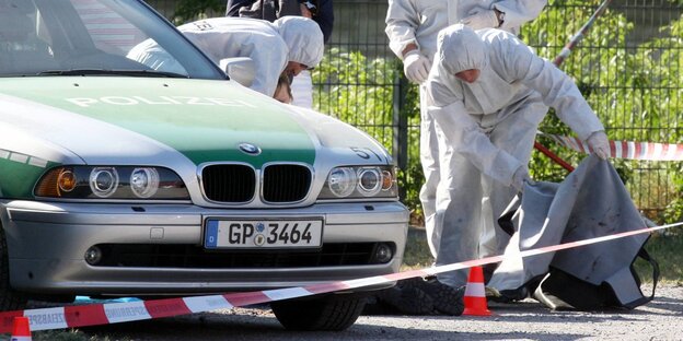 Beamte der Spurensicherung der Polizei arbeiten am 25.04.2007 auf der Theresienwiese in Heilbronn (Baden-Württemberg) an einem Tatort, an dem zuvor eine Polizeibeamtin getötet und ein weiterer Beamter schwer verletzt wurde.