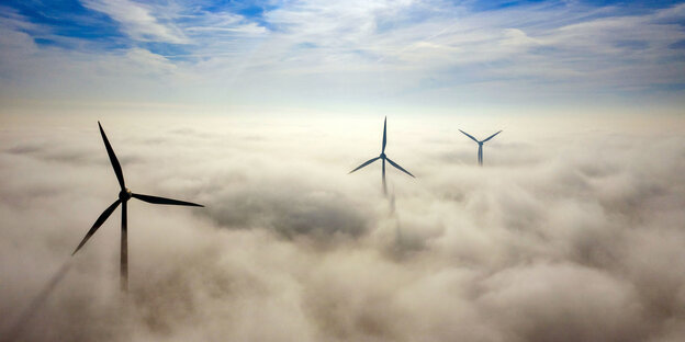 Windräder, die die Wolkendecke durchstoßen Windräder, die die Wolkendecke durchstoßen