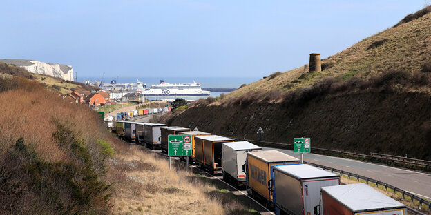 Eine LKW-Schlange steht vor einem Hafen