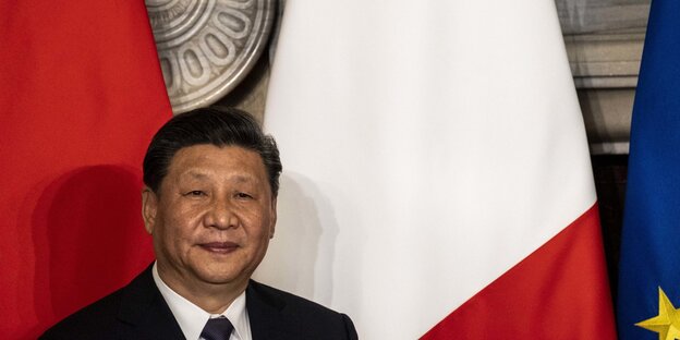 Xi Jinping steht vor den Flaggen Chinas, Italiens und der EU Xi Jinping steht vor den Flaggen Chinas, Italiens und der EU