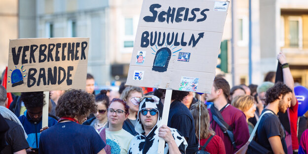 Als Kuh verkleideter Demonstrant mit Schild: "Scheiß Buuulln" Als Kuh verkleideter Demonstrant mit Schild: "Scheiß Buuulln"
