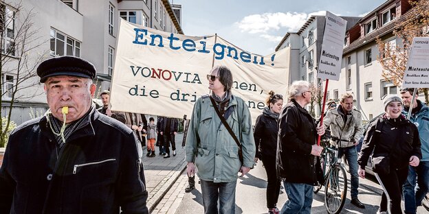 Demonstranten gehen mit Plakaten und Trillerpfeifen durch Gröpelingen.