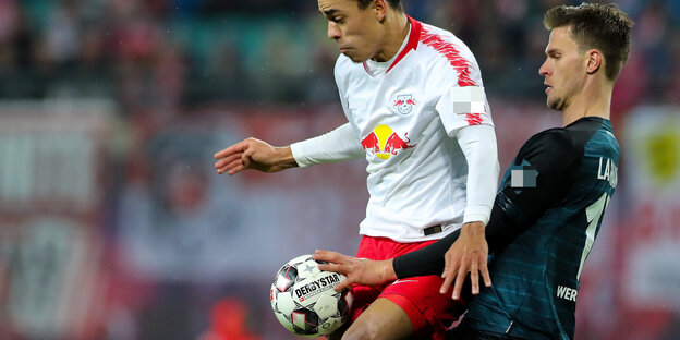 Zwei Fußballspieler ringen um den Ball, einer davon berührt ihn mit der Hand Zwei Fußballspieler ringen um den Ball, einer davon berührt ihn mit der Hand