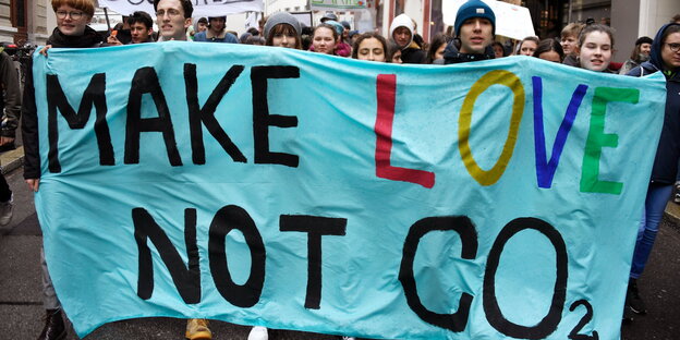 Demonstranten tragen ein Transparent, auf dem steht: „make love not CO2“ Demonstranten tragen ein Transparent, auf dem steht: „make love not CO2“