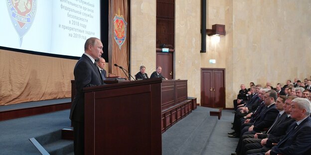 Putin spricht von einem Podium aus zu im Publikum sitzenden Geheimdienstlern Putin spricht von einem Podium aus zu im Publikum sitzenden Geheimdienstlern