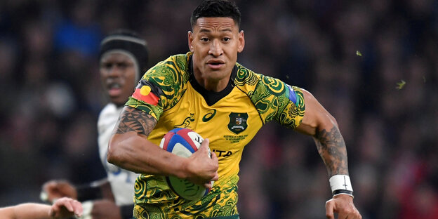 Israel Folau sprintet im gelben Trikot mit einem Rugby-Ball unter dem Arm über das Feld Israel Folau sprintet im gelben Trikot mit einem Rugby-Ball unter dem Arm über das Feld
