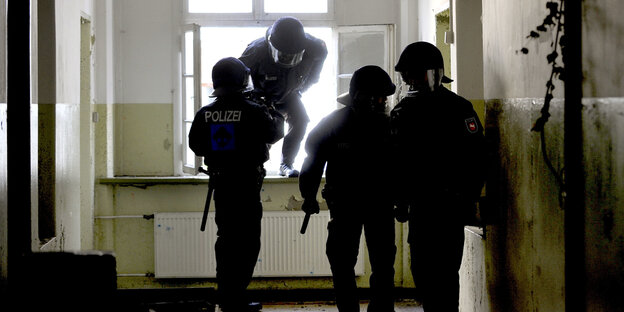 Polizisten beim Einstieg durch ein Fenster Polizisten beim Einstieg durch ein Fenster