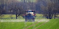 Ein Fahrzeug versprüht auf einer Wiese Pflanzenschutzmittel