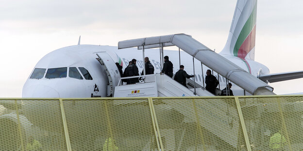 Abgelehnte Asylbewerber betreten einen Abschiebeflieger