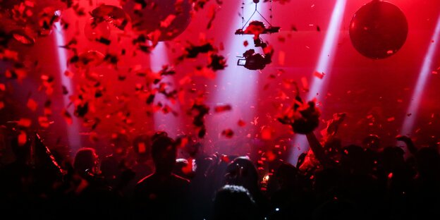 Mehrere Menschen feiern in einem Club - Foto mit Rotfilter Mehrere Menschen feiern in einem Club - Foto mit Rotfilter
