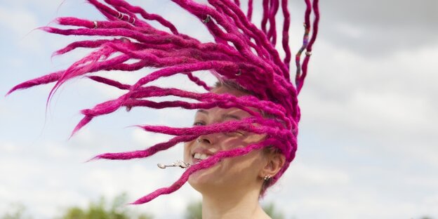 Eine weiße junge Frau mit pinken Dreadlocks Eine weiße junge Frau mit pinken Dreadlocks