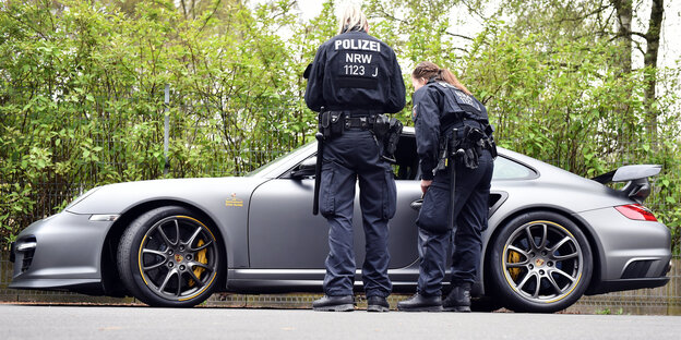 Zwei Polizistinnen vor einem Porsche Zwei Polizistinnen vor einem Porsche