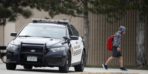 Ein Polizist hilft bei der Evakuierung der Columbine Highschool Ein Polizist hilft bei der Evakuierung der Columbine Highschool