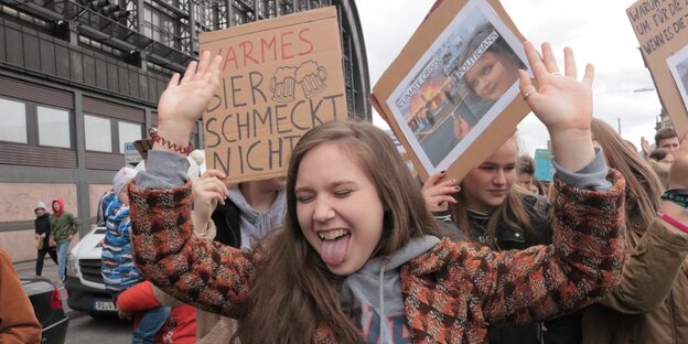 Schülerin reißt die Arme in die Luft, im Hintergrund Fridays-for-Future-Demo Schülerin reißt die Arme in die Luft, im Hintergrund Fridays-for-Future-Demo