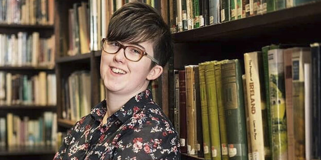 Eine Frau vor einem Bücherregal. Sie lacht. Eine Frau vor einem Bücherregal. Sie lacht.