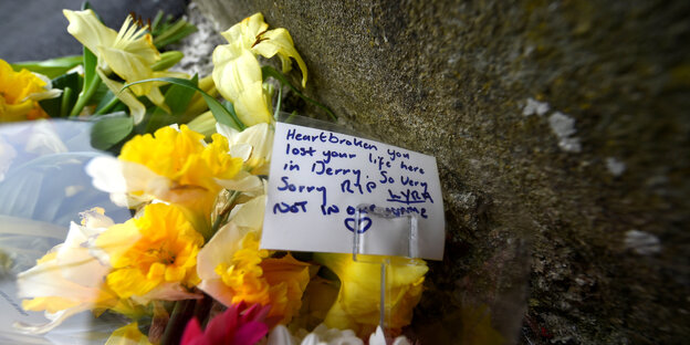 Blumen und eine Trauerkarte Blumen und eine Trauerkarte
