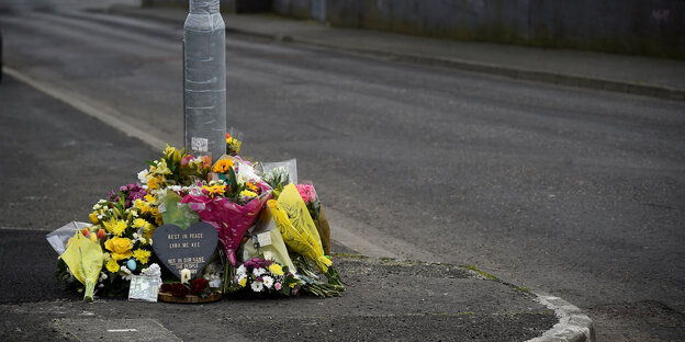 Blumen und eine Kerze liegen auf der Straße, auf der die Journalistin Lyra McKee erschossen wurde Blumen und eine Kerze liegen auf der Straße, auf der die Journalistin Lyra McKee erschossen wurde