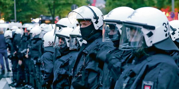 Vermummte Hamburger Bereitschaftspolizisten stehen in einer Reihe. Vermummte Hamburger Bereitschaftspolizisten stehen in einer Reihe.