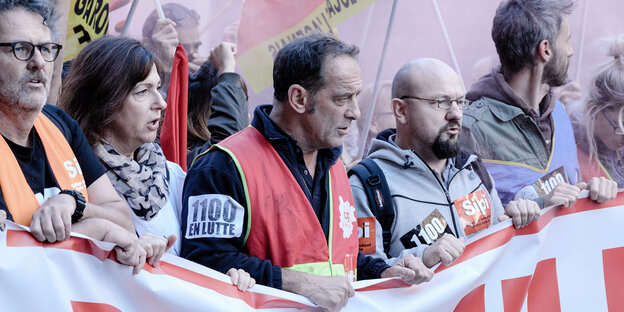 Streikende Arbeiter bei einer Demonstration auf der Straße. Streikende Arbeiter bei einer Demonstration auf der Straße.