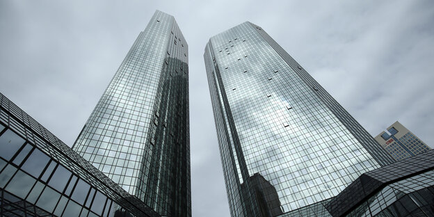 Die Hochhäuser der Deutschen Bank von unten nach oben fotografiert, dahinter grauer Himmel Die Hochhäuser der Deutschen Bank von unten nach oben fotografiert, dahinter grauer Himmel