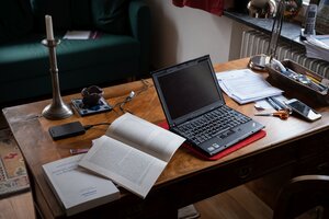 Ein Schreibtisch mit aufgeschlagenem Laptop und Büchern Ein Schreibtisch mit aufgeschlagenem Laptop und Büchern