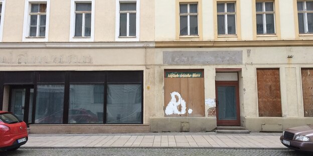 Zwei Autos stehen vor einer Häuserwand. Zwei Autos stehen vor einer Häuserwand.