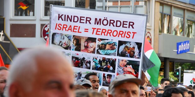 Demonstranten halten Schild mit der Aufschrift: Israel gleich Terrorist Demonstranten halten Schild mit der Aufschrift: Israel gleich Terrorist