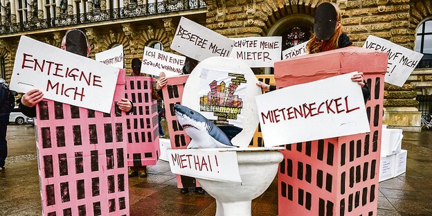 Häuser aus Pappe stehen auf dem Hamburger Rathausmarkt. Auf Schildern stehen Parolen wie "Enteigne mich" oder "Besetze mich". Häuser aus Pappe stehen auf dem Hamburger Rathausmarkt. Auf Schildern stehen Parolen wie "Enteigne mich" oder "Besetze mich".