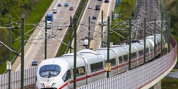 Ein ICE fährt über einer Brücke über der Autobahn Ein ICE fährt über einer Brücke über der Autobahn