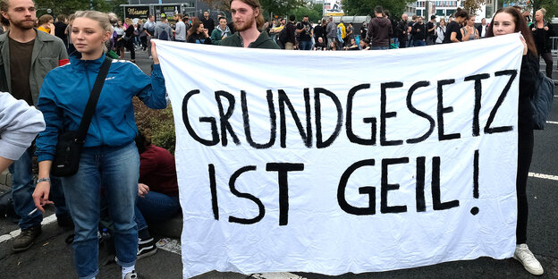 Mehrere junge Menschen halten ein Transparent auf dem steht: „Grundgesetz ist geil“