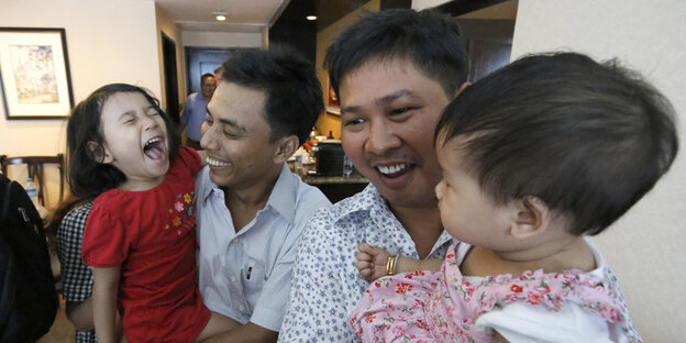 Kyaw Soe Oo und Wa Lone haten ihre Kinder in den Armen Kyaw Soe Oo und Wa Lone haten ihre Kinder in den Armen