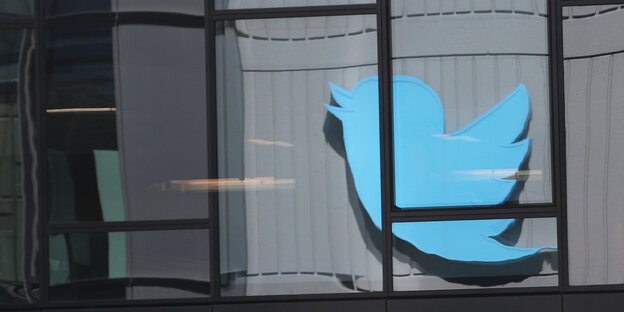 Das Twitter-Logo, ein fliegender Spatz, an einer Fassade Das Twitter-Logo, ein fliegender Spatz, an einer Fassade