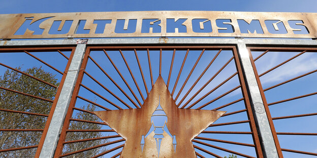 Das Tor vor dem Musik- und Kulturfestival Fusion in Mecklenburg Vorpommern mit der Auschrift "Kulturkosmos" und der typischen Rakete Das Tor vor dem Musik- und Kulturfestival Fusion in Mecklenburg Vorpommern mit der Auschrift "Kulturkosmos" und der typischen Rakete