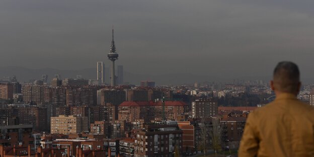 Ein Mann schaut von einer Aussichtsplattform auf die Dächer Madrids. Ein Mann schaut von einer Aussichtsplattform auf die Dächer Madrids.