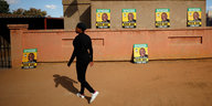 Eine Frau läuft an ANC-Wahlplakaten vorbei