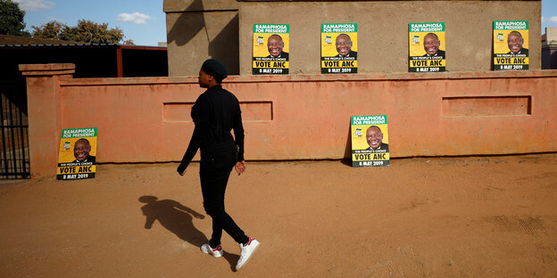 Eine Frau läuft an ANC-Wahlplakaten vorbei Eine Frau läuft an ANC-Wahlplakaten vorbei