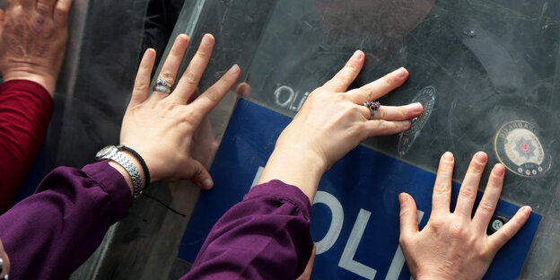 Demonstrierende stoßen mit ihren Händen gegen die Schilde der türkischen Polizei Demonstrierende stoßen mit ihren Händen gegen die Schilde der türkischen Polizei