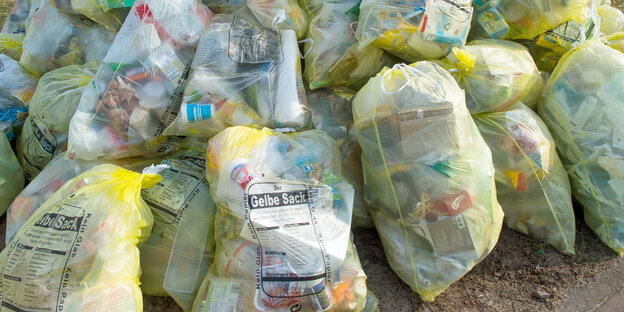Gestapelte gelbe Säcke mit Plastikverpackungen Gestapelte gelbe Säcke mit Plastikverpackungen