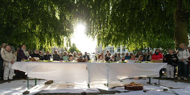 Brot und Blumen liegen auf einem Tisch anlässlich eines Gottesdienstes unter freiem Himmel. Brot und Blumen liegen auf einem Tisch anlässlich eines Gottesdienstes unter freiem Himmel.